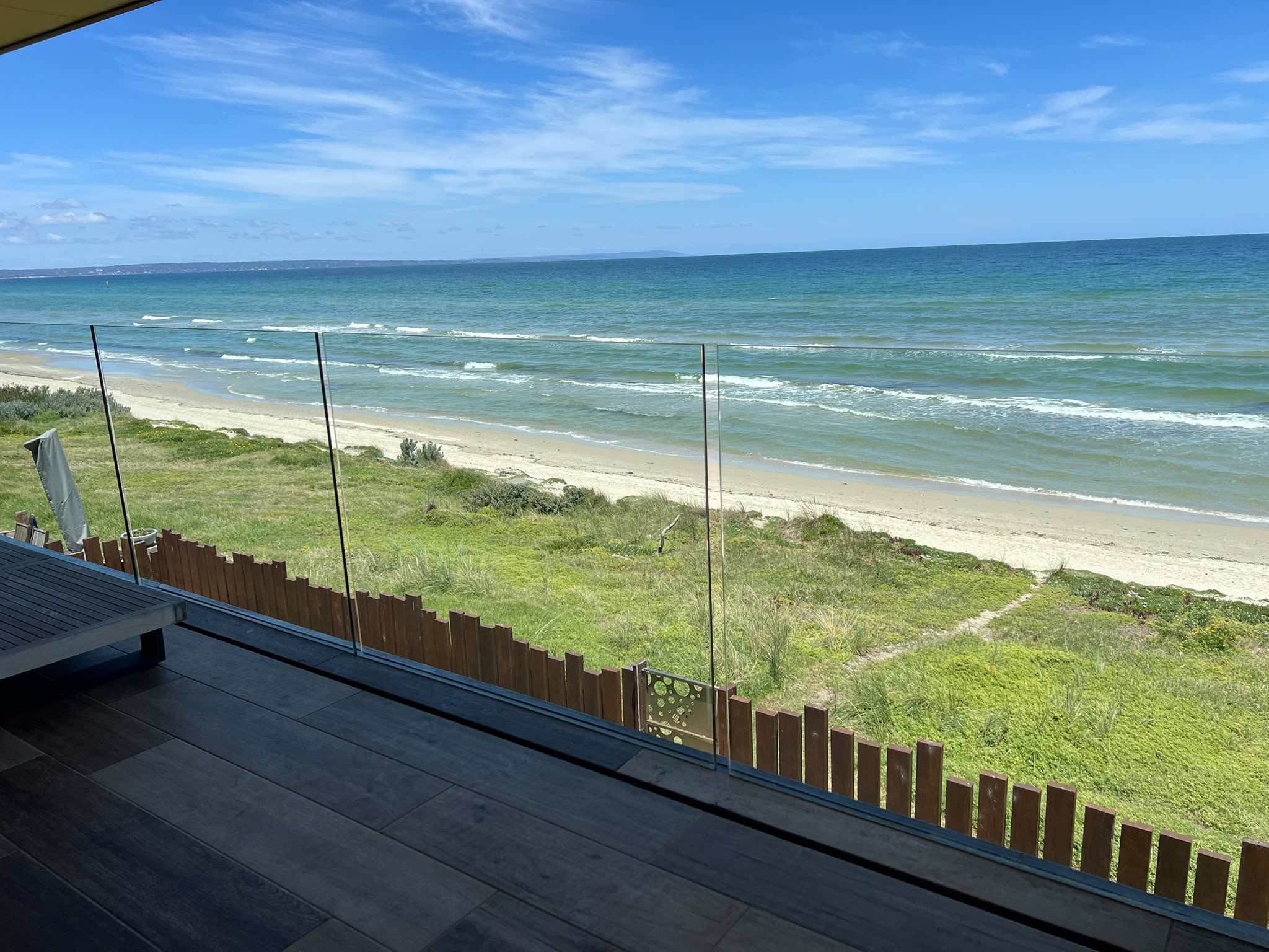 Clean glass balustrade overlooking a beach