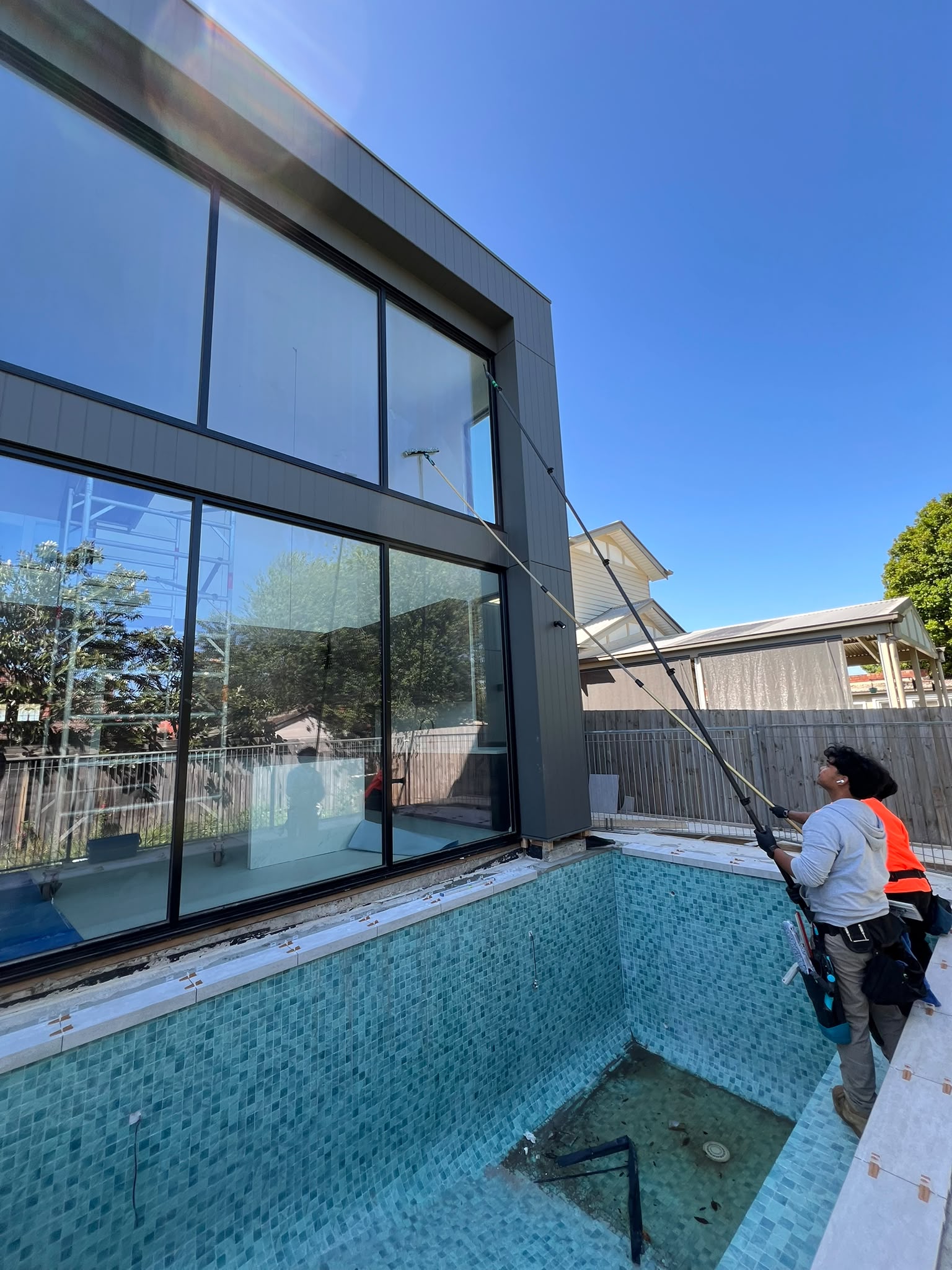 High exterior windows being cleaned with water-fed poles